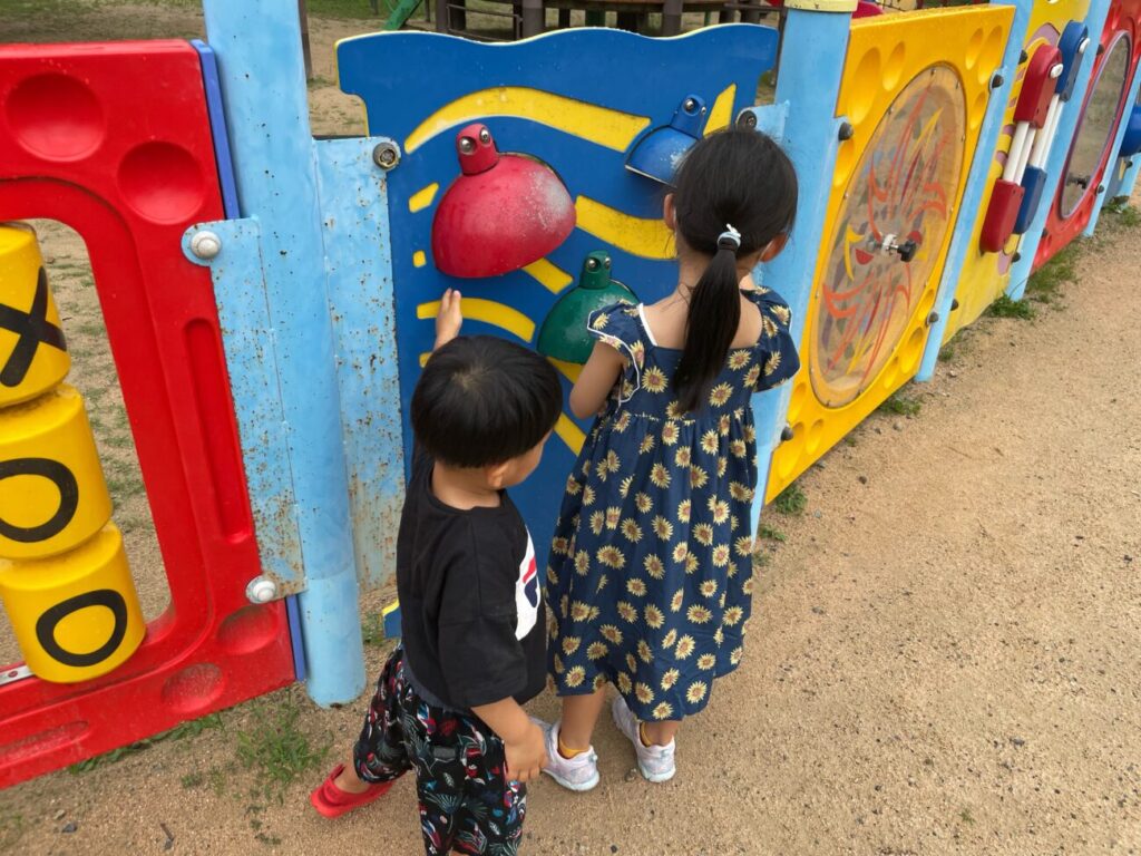 萩市の夏みかんランドの鐘の遊具を鳴らす子供