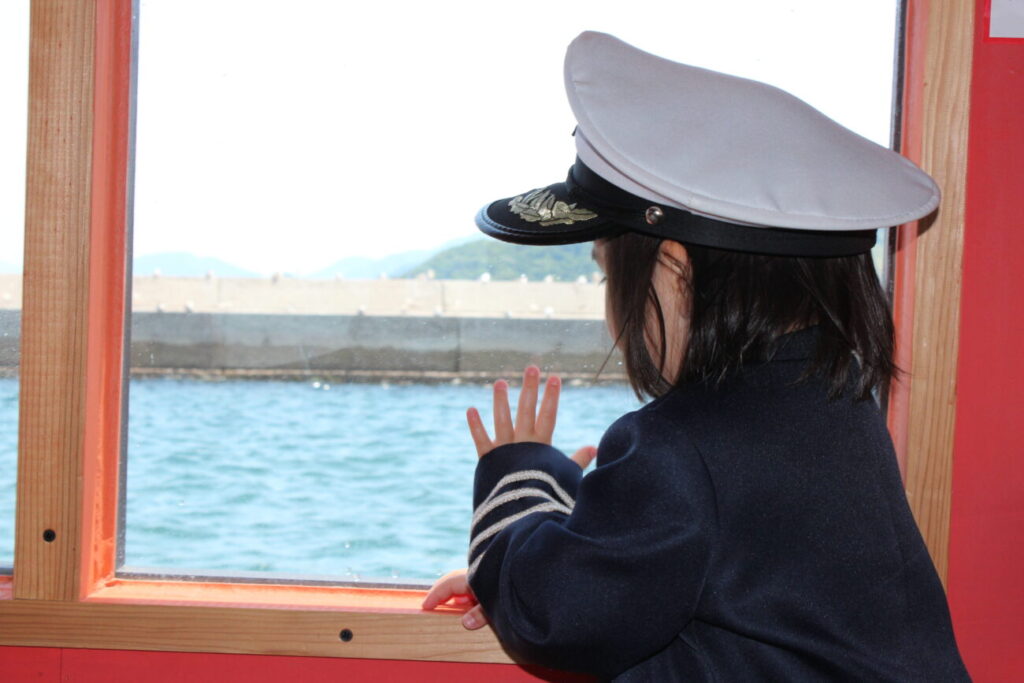 長門おもちゃ美術館のキッズクルーズ船から手をふる子供