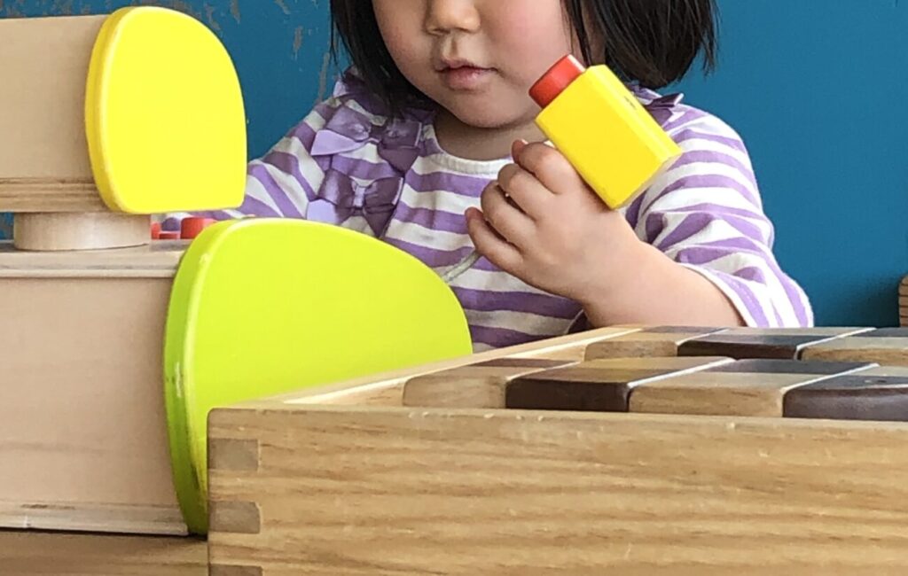 長門おもちゃ美術館の木のレジで遊ぶ子供