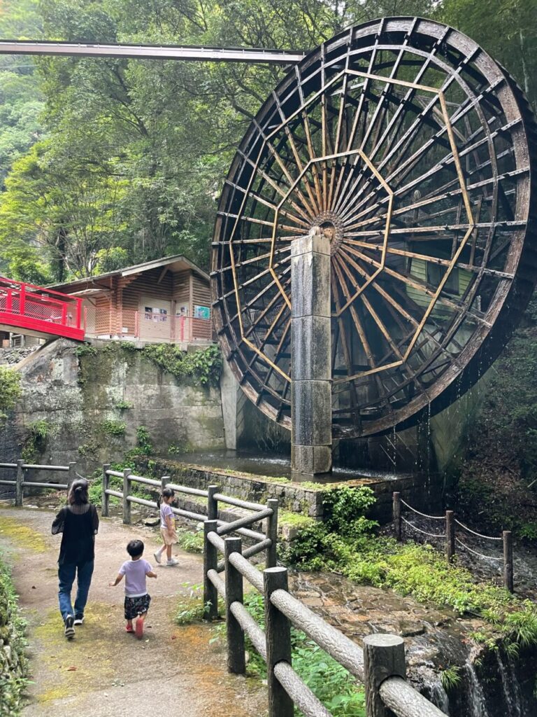観音水車でかまるくんを見上げるこどもと親