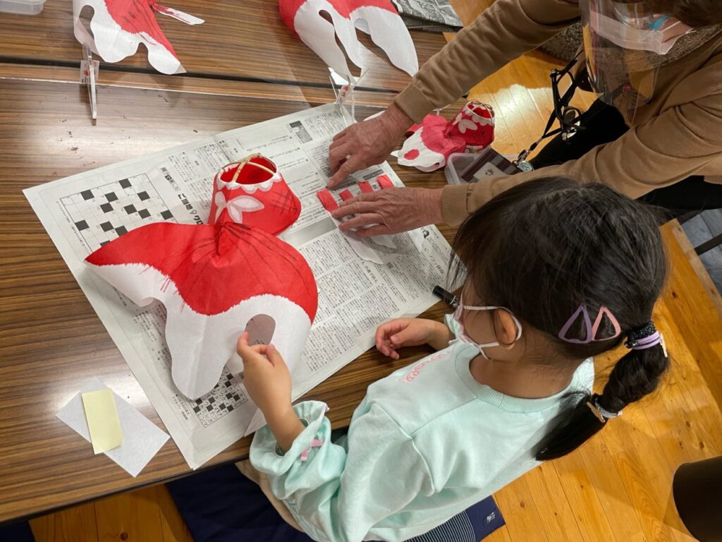 柳井市の金魚ちょうちん制作体験で先生から教えてもらっているこども