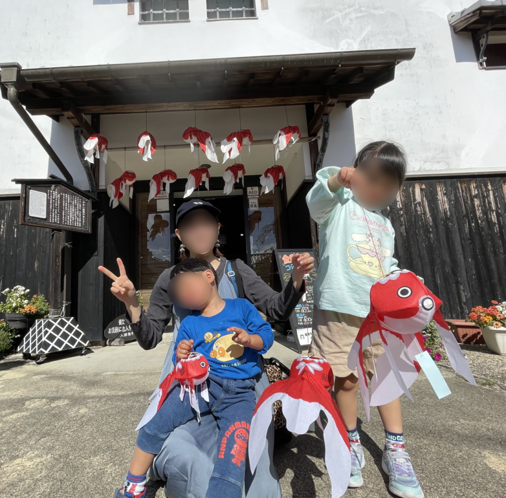 やない西蔵の入り口前で記念撮影する家族